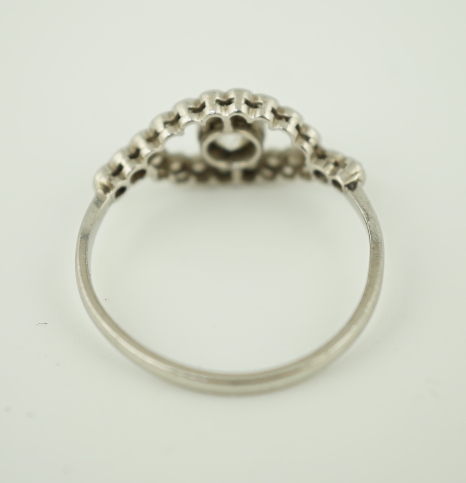 A white metal and single stone elliptical shaped ring, with diamond set border and shoulders, size M, gross weight 2.1 grams.